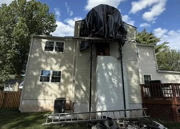 Structurally deteriorated chimney on a Doylestown PA colonial showing spalling brick and open mortar joints before rebuild