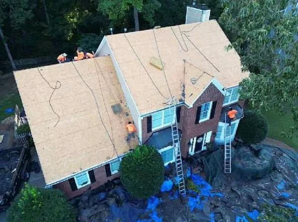 Storm-damaged roof on a Warminster PA split-level showing missing shingles and exposed decking after nor'easter